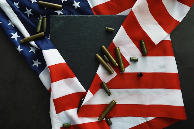 Bandera estadounidense sobre un fondo gris Fondo militar con balas EE. UU. Y el oeste colectivo de la UE