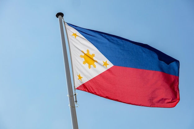 Bandera de Filipinas ondeando contra el cielo azul claro