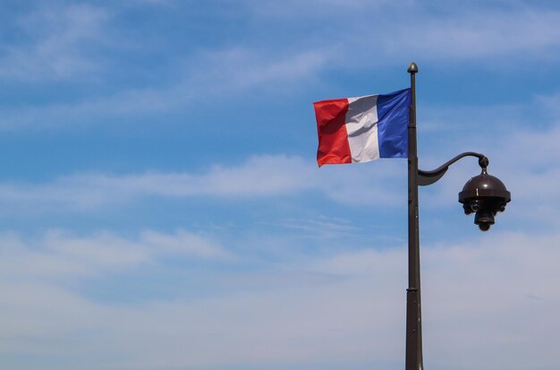 Una bandera francesa en una farola en parís francia abril