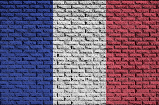 Foto la bandera de francia está pintada en una vieja pared de ladrillos