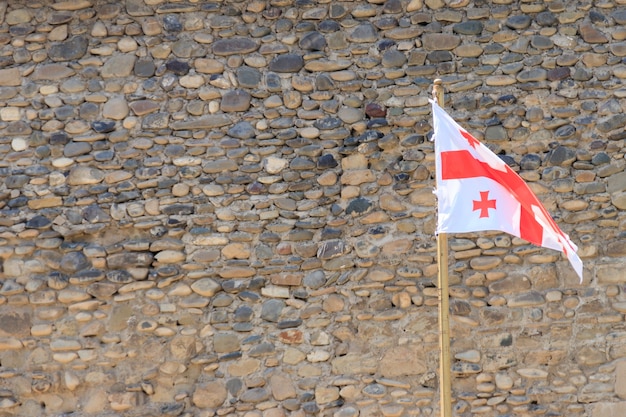 Bandera de Georgia contra la antigua muralla de la fortaleza