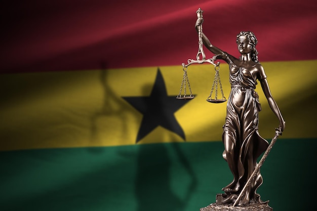 Bandera de Ghana con estatua de la dama de la justicia y escalas judiciales en cuarto oscuro Concepto de juicio y castigo