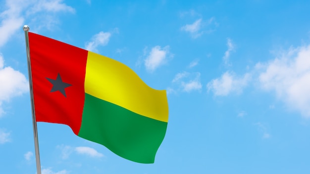 Bandera de Guinea-Bissau en el poste. Cielo azul. Bandera nacional de Guinea-Bissau