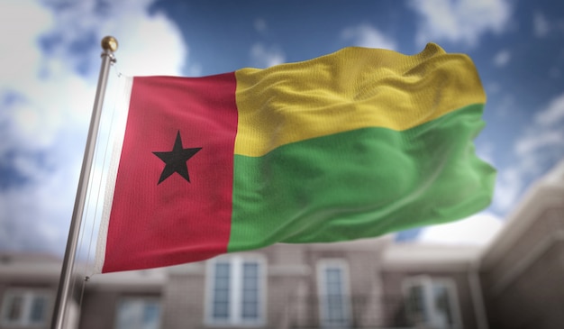 Bandera de Guinea-Bissau Representación 3D sobre el fondo del edificio de cielo azul