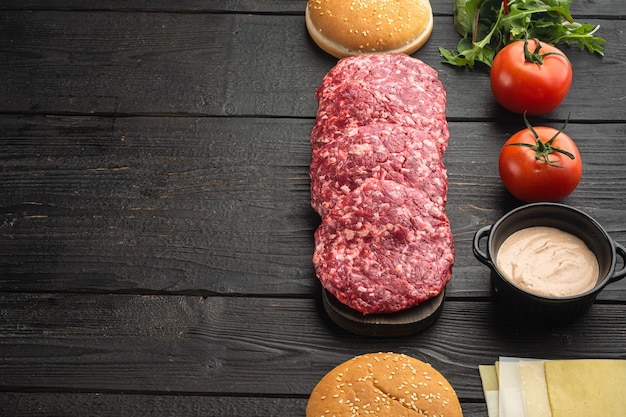 Bandera de hamburguesa. Ingredientes crudos para hamburguesa, sobre mesa de madera negra