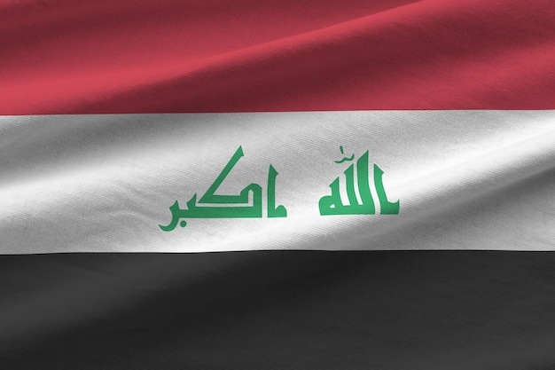 Bandera de Irak con grandes pliegues ondeando de cerca bajo la luz del estudio en el interior Los símbolos y colores oficiales en la pancarta