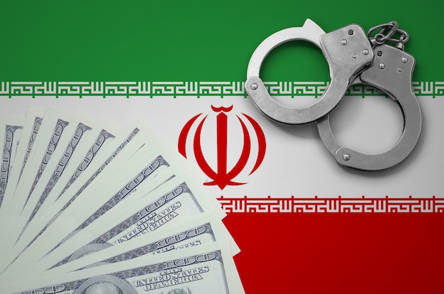 Bandera de Irán con esposas y un fajo de dólares. El concepto de operaciones bancarias ilegales en moneda estadounidense