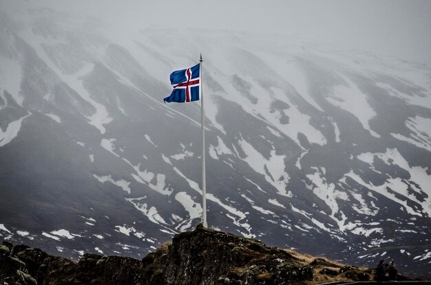 Bandera islandesa en una montaña cubierta de nieve