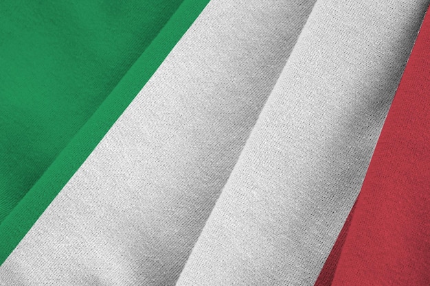Bandera de Italia con grandes pliegues ondeando de cerca bajo la luz del estudio en el interior Los símbolos y colores oficiales en la pancarta