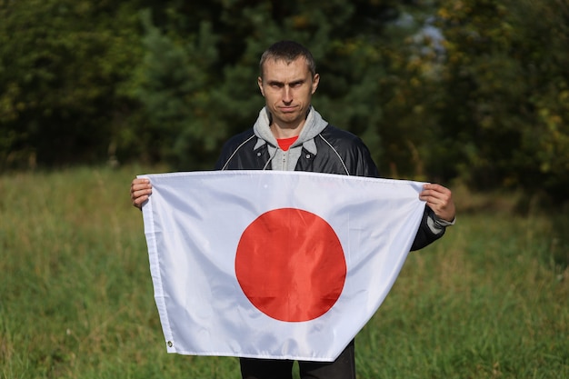 Bandera de Japón en manos humanas