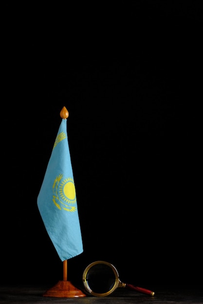 Bandera de Kazajstán y lupa sobre fondo negro.Concepto, bajo estrecha atención.
