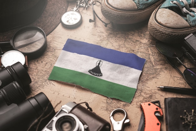 Bandera de Lesotho entre los accesorios del viajero en el viejo mapa vintage. Concepto de destino turístico.