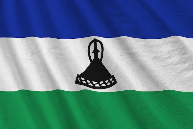 Bandera de Lesotho con grandes pliegues ondeando de cerca bajo la luz del estudio en el interior Los símbolos y colores oficiales en la pancarta