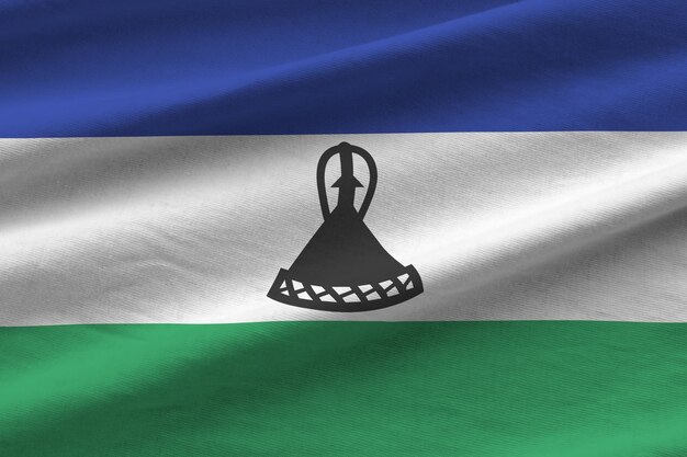 Bandera de Lesotho con grandes pliegues ondeando de cerca bajo la luz del estudio en el interior Los símbolos y colores oficiales en la pancarta