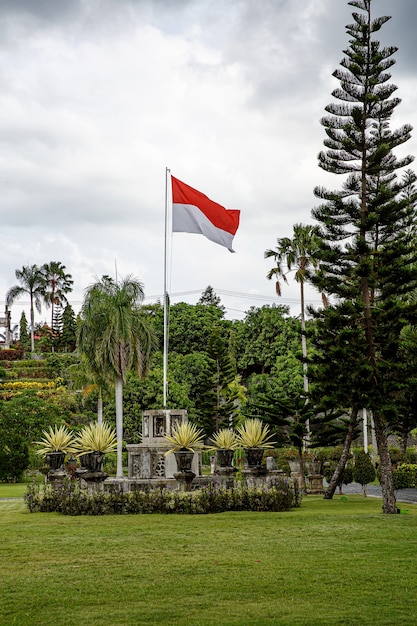 Foto bandera levantada de indonesia en el parque al aire libre.