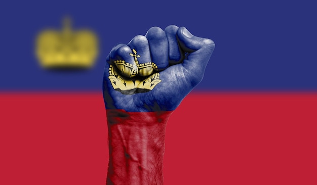 Bandera de Liechtenstein pintada en un concepto de protesta de fuerza de puño cerrado