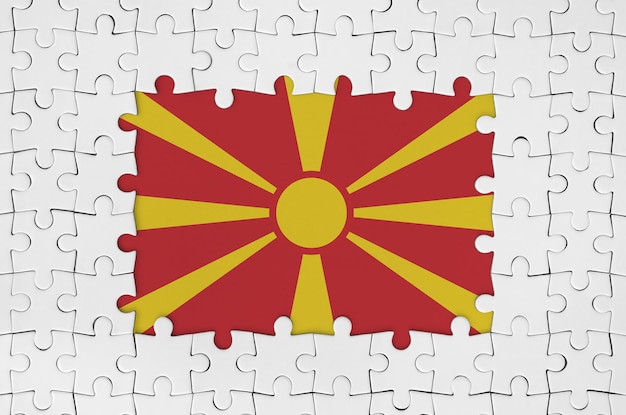 Foto bandera de macedonia en marco de piezas de rompecabezas blancas con parte central faltante