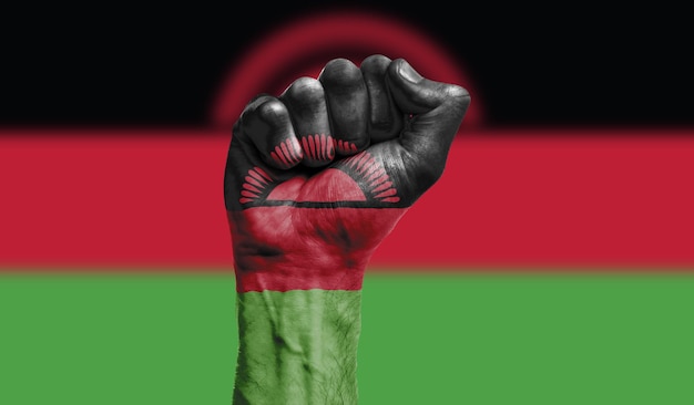 Bandera de malawi pintada en un concepto de protesta de fuerza de puño cerrado