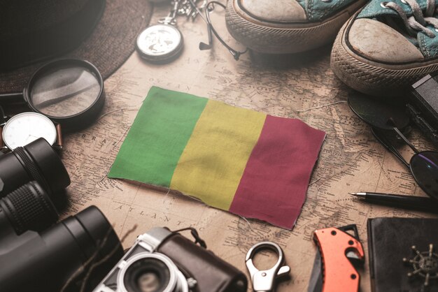 Bandera de Malí entre los accesorios del viajero en el mapa antiguo de la vendimia. Concepto de destino turístico.