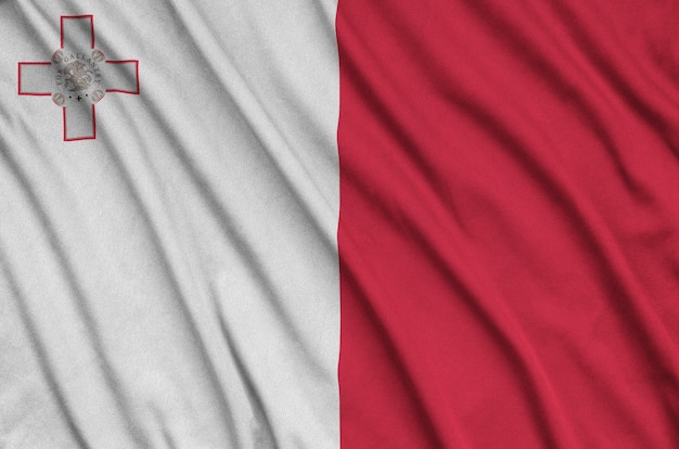 La bandera de Malta está representada en una tela de tela deportiva con muchos pliegues.