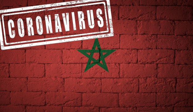 Bandera de Marruecos con proporciones originales. estampado de Coronavirus. textura de la pared de ladrillo. Concepto de virus corona. Al borde de una pandemia COVID-19 o 2019-nCoV.