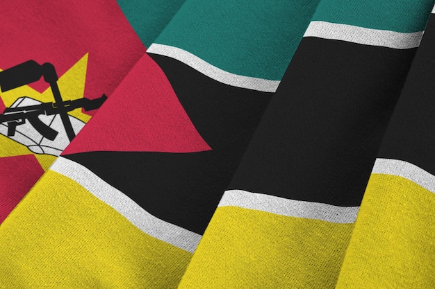 Bandera de Mozambique con grandes pliegues ondeando de cerca bajo la luz del estudio en el interior Los símbolos y colores oficiales en la pancarta