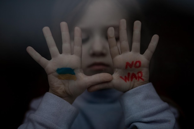 Foto bandera nacional azul amarilla de ucrania cara de niña detener la guerra y la paz en el mundo apoyo estatal en la guerra europa unida contra rusia ansiedad y anticipación lágrimas de niños salvar ucrania