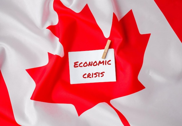 La bandera nacional de Canadá Bandera canadiense con la hoja de arce y el mensaje de la nota de papel CRISIS ECONÓMICA