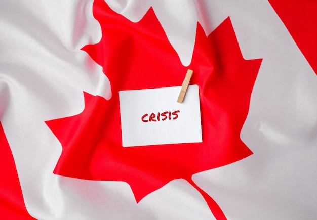 La bandera nacional de Canadá Bandera canadiense con la hoja de arce y el texto del mensaje de la nota de papel CRISIS