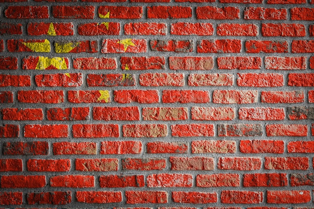 La bandera nacional de China en una vieja pared de ladrillos