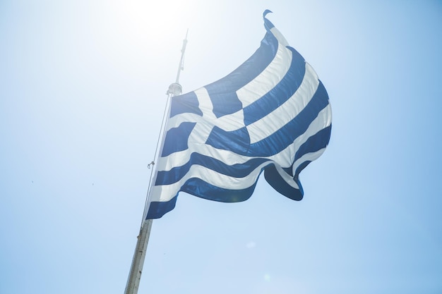 Bandera nacional de Grecia sobre el cielo Acrópolis de Atenas en Grecia