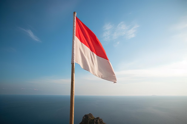 Bandera nacional de Indonesia ondeando en el cielo azul sobre el fondo del océano Bandera roja y blanca