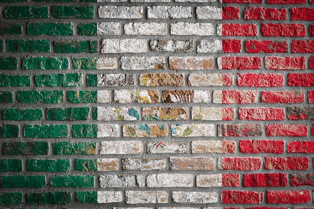 La bandera nacional de México en una vieja pared de ladrillos