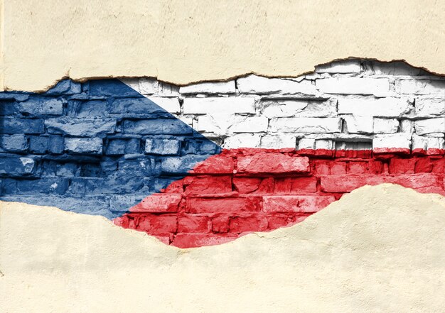 Bandera nacional de la República Checa sobre un fondo de ladrillo. Pared de ladrillo con yeso, fondo o textura parcialmente destruidos.