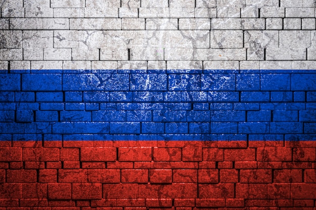 La bandera nacional de Rusia sobre fondo de pared de ladrillo.