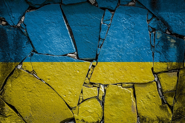 Foto bandera nacional de ucrania que representa en colores de pintura en un antiguo muro de piedra. bandera de banner en el fondo de la pared rota.