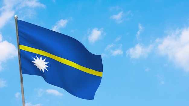 Bandera de Nauru en el poste. Cielo azul. Bandera nacional de nauru