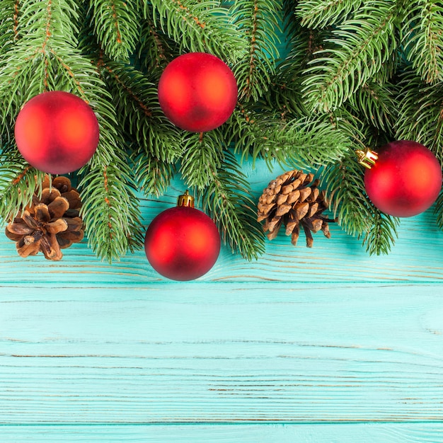 Bandera de la Navidad con el árbol verde, decoraciones rojas de la bola, conos en fondo texturizado de madera de la menta