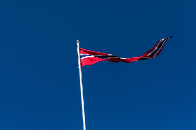 Bandera noruega contra el cielo azul, bandera de Noruega