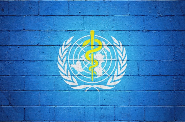 Bandera de la Organización Mundial de la Salud en una pared de ladrillos