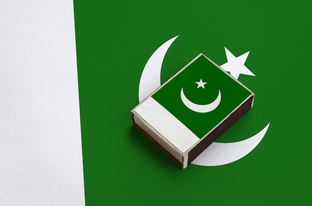 La bandera de Pakistán se representa en una caja de fósforos que se encuentra en una bandera grande