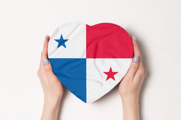 Bandera de Panamá en una caja en forma de corazón en manos femeninas.
