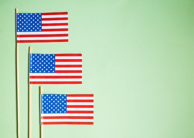 Bandera de papel miniatura de Estados Unidos. Bandera americana en el fondo verde