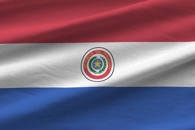 Bandera de Paraguay con grandes pliegues ondeando de cerca bajo la luz del estudio en el interior de los símbolos oficiales y