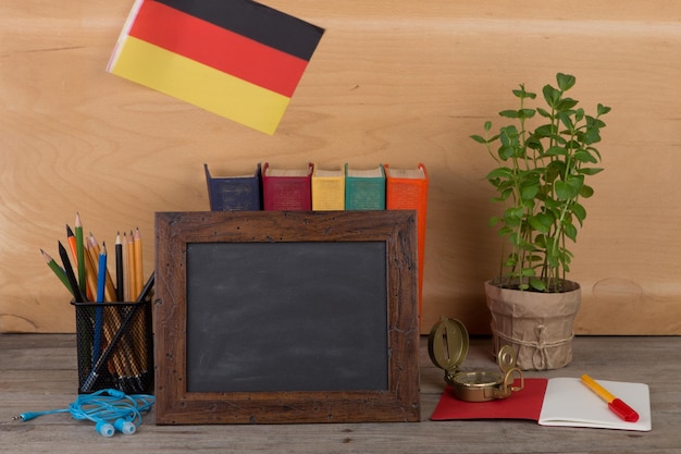 Bandera de pizarra en blanco de la cancillería de libros de Alemania sobre mesa y fondo de madera