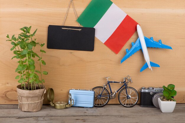 Bandera de pizarra en blanco del modelo de avión de Italia pequeña bicicleta y brújula de cámara de maleta