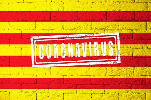 Bandera de las regiones o comunidades de España Cataluña con proporciones originales. estampado de Coronavirus. textura de la pared de ladrillo. Concepto de virus corona. Al borde de una pandemia COVID-19 o 2019-nCoV.