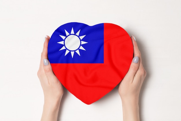 Bandera de la República de China en una caja en forma de corazón en manos femeninas