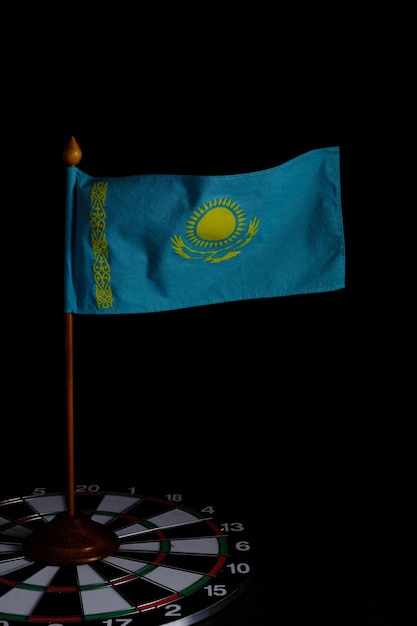 Bandera de la República de Kazajstán en un tablero de dardos sobre un fondo oscuro.