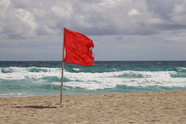 Bandera roja en playa con oleaje.